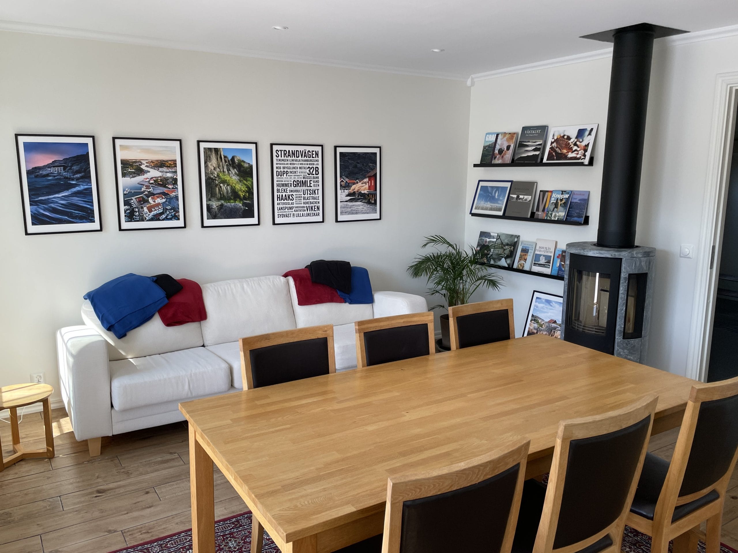 Gemensam matplats med soffa, fotokonst och braskamin